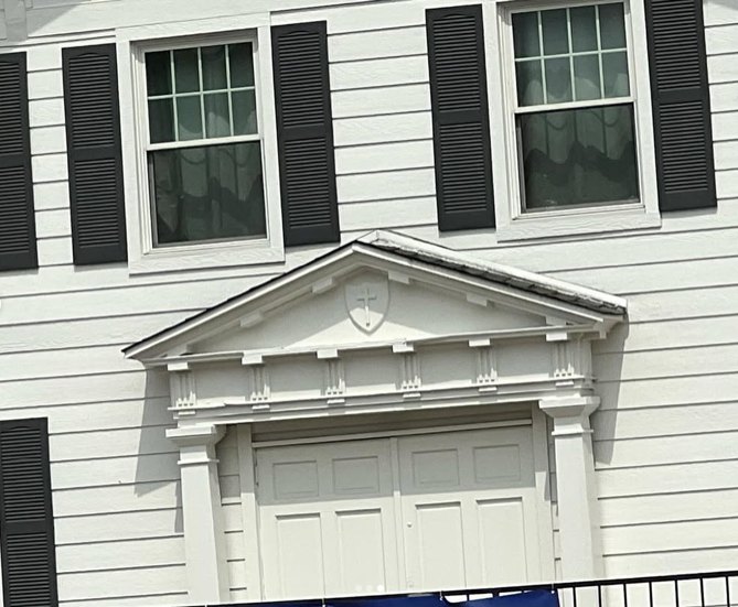 Historic building finished in white with black shutters and detailed trim