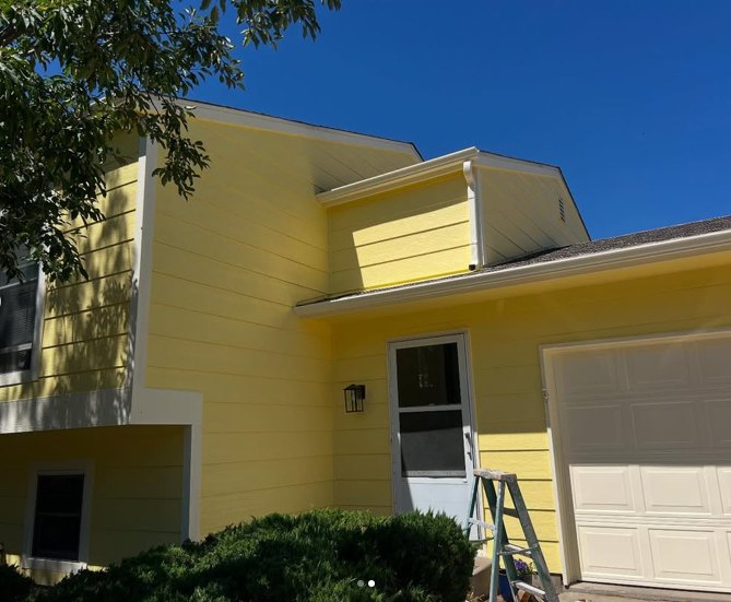 Same home after full exterior repaint in yellow with white trim